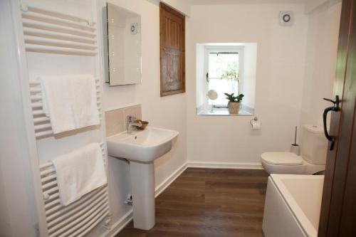 uma casa de banho branca com um lavatório e um WC em Marrington Mill - Marrington Escapes em Chirbury