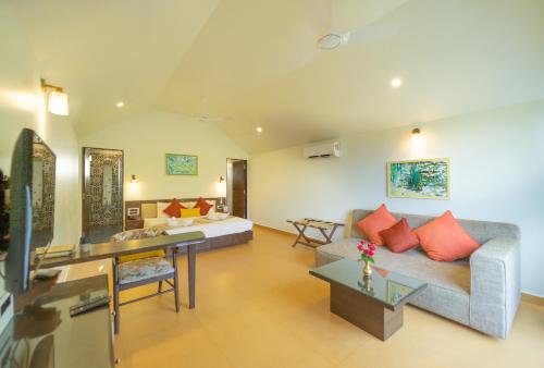 a living room with a couch and a table at Resort Terra Paraiso in Calangute