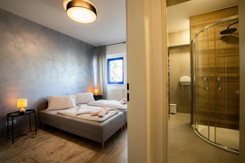 um quarto com uma cama e uma cabina de duche ao nível do chão em Športové a relaxačné centrum - ŠRC em Stará ľubovňa