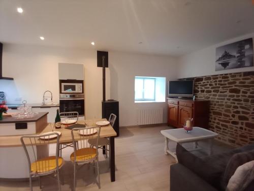 a kitchen and a living room with a table and chairs at GITE LE MOULIN en Baie du MONT ST MICHEL in Bacilly