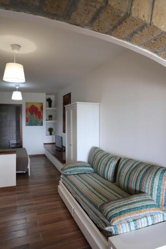 un soggiorno con un lungo divano in una camera di B&B Le Colline Country House a Anguillara Sabazia