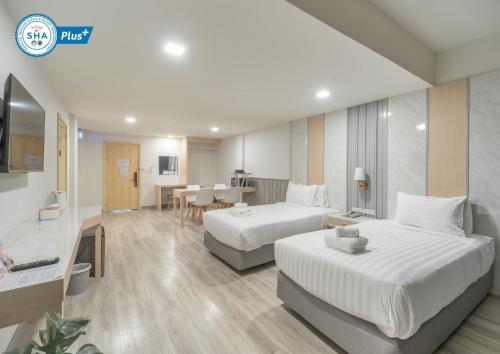 a hotel room with two beds and a dining room at The Space Hotel Lampang in Lampang