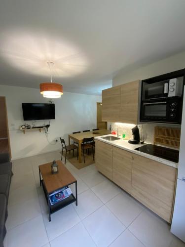 un salon avec une cuisine et une table dans l'établissement APPARTEMENT 3 CHAMBRES A LA MONTAGNE, à Saint-Michel-de-Maurienne