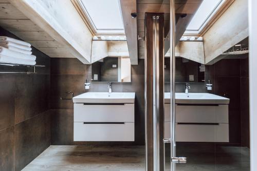 a bathroom with two sinks and a skylight at Mine House in Trento