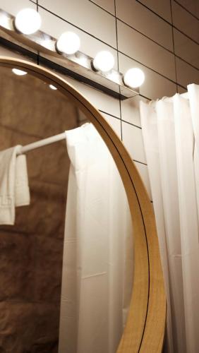 a mirror in a bathroom with white curtains at Tzefania Hotel in Jerusalem