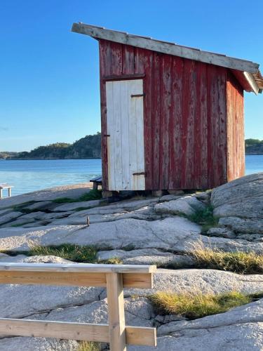 a small shack on the shore of a body of water at Resö Hamnmagasin vandrarhem in Resö