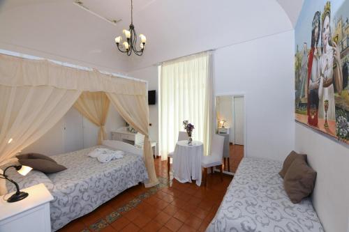 a bedroom with a bed and a table in it at ApartHotel Antica Repubblica in Amalfi center at 100mt from the sea with payment parking in Amalfi
