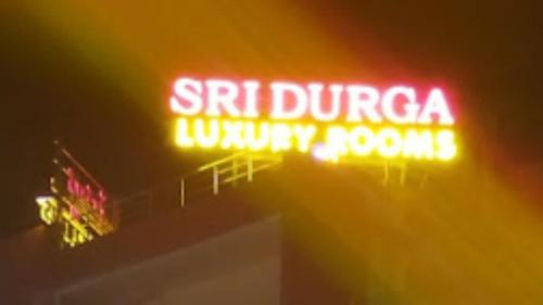 un'insegna al neon sulla sommità di un edificio di Sri Durga Luxury A/C Rooms,Sircilla a Sirsilla