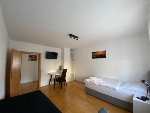 ein Schlafzimmer mit einem Bett und einem Tisch darin in der Unterkunft Apartment Q im Zentrum von Königsbronn in Königsbronn