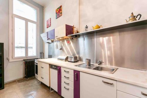 une cuisine avec un évier et un plan de travail dans l'établissement L'Argenterie - Spacieux, Centrale & Climatisation, à Montpellier