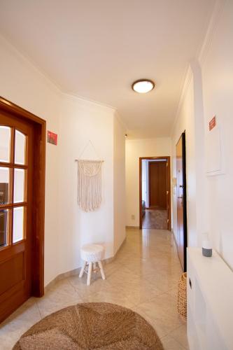 a living room with a table and a stool at Modern apartment in Colinas de Cruzeiro in Odivelas
