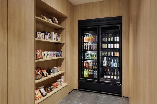 a walk in pantry with a large black refrigerator at Fairfield by Marriott Kumamoto Aso in Aso