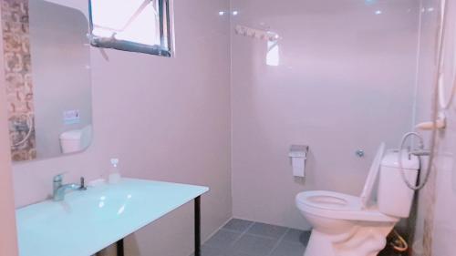 a white bathroom with a toilet and a sink at new pind balluchi inn in Pattaya