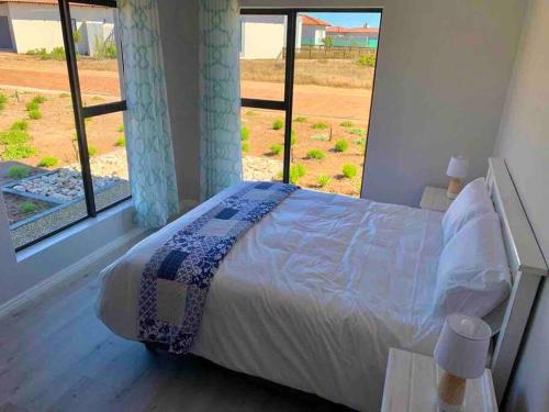 une chambre avec un lit et une grande fenêtre dans l'établissement Coastal & Country Living in Langebaan, à Langebaan