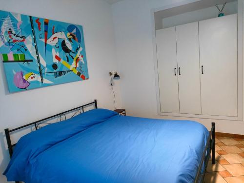 um quarto com uma cama e um quadro na parede em Appartamento Fontesecco em LʼAquila