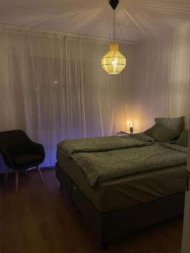 a bedroom with a bed and a lamp and a chair at Bronx - Apartment in Vantaa