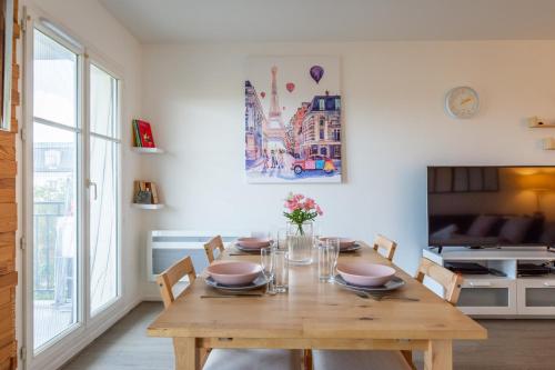 une salle à manger avec une table en bois et des chaises dans l'établissement City Of Love By Plaza - Proche Disneyland Paris, à Serris