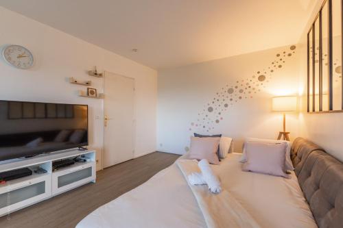 un salon avec un canapé et une télévision à écran plat dans l'établissement City Of Love By Plaza - Proche Disneyland Paris, à Serris