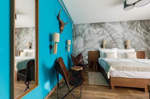 1 Schlafzimmer mit einem Bett und 2 Stühlen in der Unterkunft Hotel Historia Malomkert in Veszprém