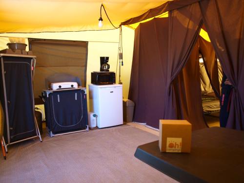 a room with a tent with a refrigerator and a microwave at Oh! Camping - Les Roquilles Palavas les Flots in Palavas-les-Flots