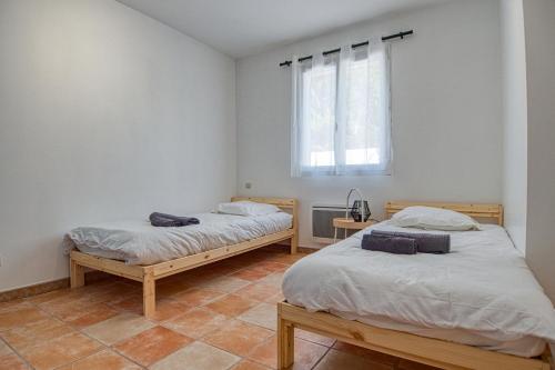 2 łóżka pojedyncze w pokoju z oknem w obiekcie Villa provençale proche mer au calme w mieście Martigues