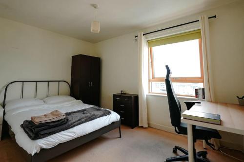 a bedroom with a bed and a desk and a computer at Luxurious Top Floor 2 Bedroom by Westfield and ABBA! in London