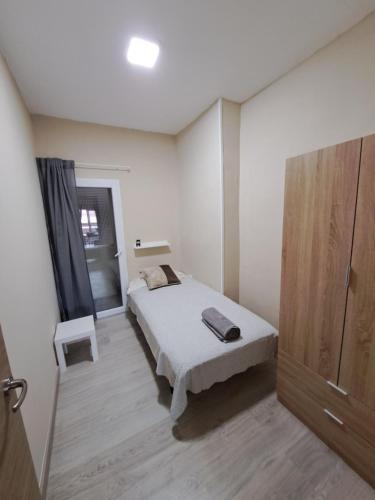 Habitación pequeña con cama y ventana en MERIDIANA sant andreu 4 bedrooms en Barcelona