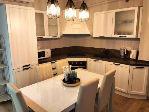 una cucina con armadi bianchi e tavolo e sedie bianchi di Appartamento LA RIBOLLITA a Pesaro