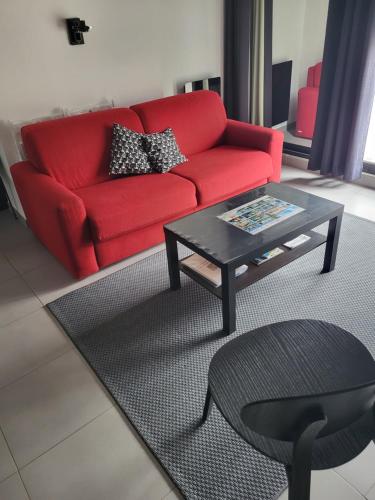 a living room with a red couch and a coffee table at Joli appartement avec vue sur la Loire in Amboise