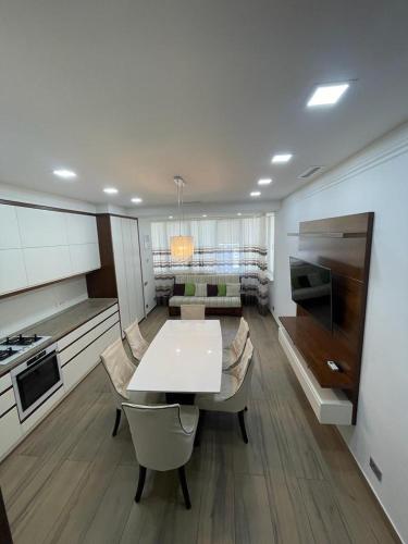 eine Küche und ein Wohnzimmer mit einem weißen Tisch und Stühlen in der Unterkunft Best VIEW apartments !!!! in Chişinău