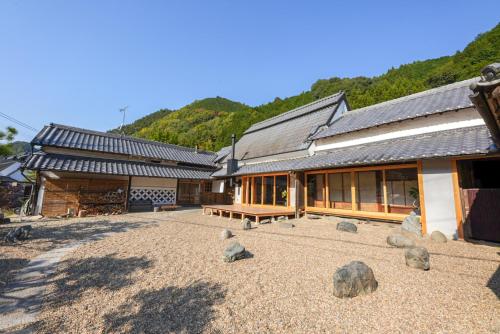 a building with rocks on the ground in front of it at 奥明日香古民家一棟貸し宿 弥栄 Yasaka in Asuka