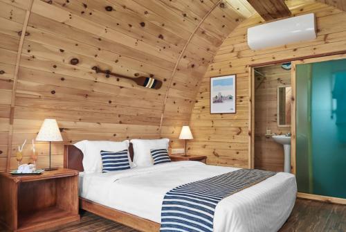 - une chambre avec un lit et un mur en bois dans l'établissement Pod Village by Independence Hotels, à Sihanoukville