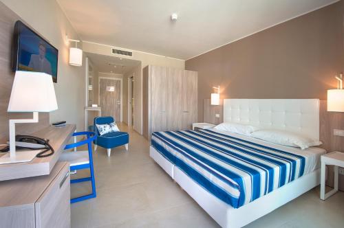 Cette chambre comprend un lit et un bureau. dans l'établissement Isola di Albarella Hotel Capo Nord, à Albarella