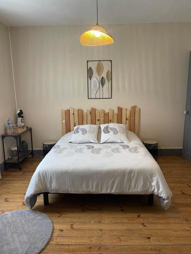 1 dormitorio con 1 cama grande y cabecero de madera en Chambre privée et sa salle de bain attenante en Mazamet