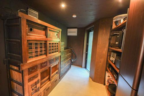 a room with a kitchen with wooden cabinets at 奥明日香古民家一棟貸し宿 弥栄 Yasaka in Asuka