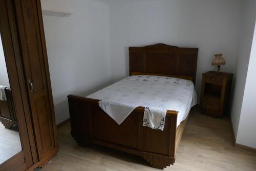 - une chambre avec un lit en bois et une table de chevet dans l'établissement La bergerie des Moureres, à Trézioux