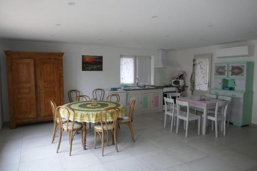 une cuisine et une salle à manger avec une table et des chaises dans l'établissement La bergerie des Moureres, à Trézioux