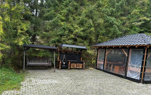 two gazebos with a table and a bench in a yard at Chata Olina in Oravice
