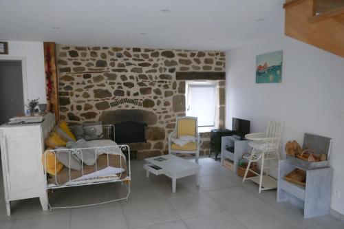 - un salon avec une cheminée en pierre et des chaises dans l'établissement La bergerie des Moureres, à Trézioux