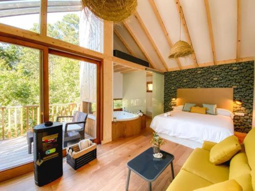 um quarto com uma cama e uma sala de estar em Cabanas de Udra em Pontevedra