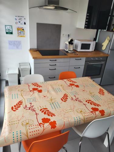 a kitchen with a table with orange chairs around it at Joli appartement avec vue sur la Loire in Amboise