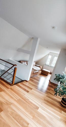 a living room with a staircase and wooden floors at Ferienwohnungen am Tor in Langenburg