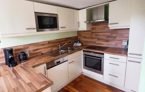 a kitchen with white cabinets and wooden counter tops at Ferienwohnungen am Tor in Langenburg