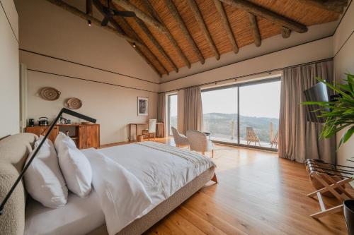 a bedroom with a bed and a large window at MANİCİ ÇİFTLİK in Ayvacık