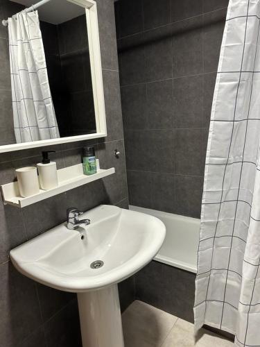 a bathroom with a sink and a mirror and a tub at Apartamento La Timba in Alcossebre