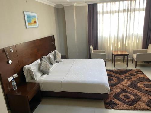 سرير أو أسرّة في غرفة في Geza Apartment Hotel