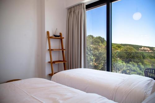 Una habitación de hotel con dos camas y una gran ventana. en Villa Blauw with Infinity Pool & Sea Views, en Vasiliki