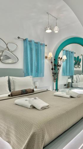 a bedroom with two beds with blue curtains at Anastasia Princess Luxury Beach Residence, Adults Only in Perissa