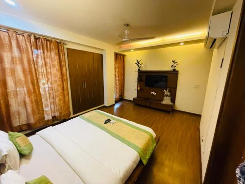 a hotel room with a bed and a television at DIVINE INDIA SERVICE APARTMENT 4BHK , J-191 , SAKET in New Delhi
