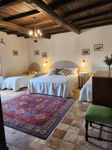 a bedroom with two beds and a rug at Villa Arzilla Antica Residenza di campagna in Vitorchiano